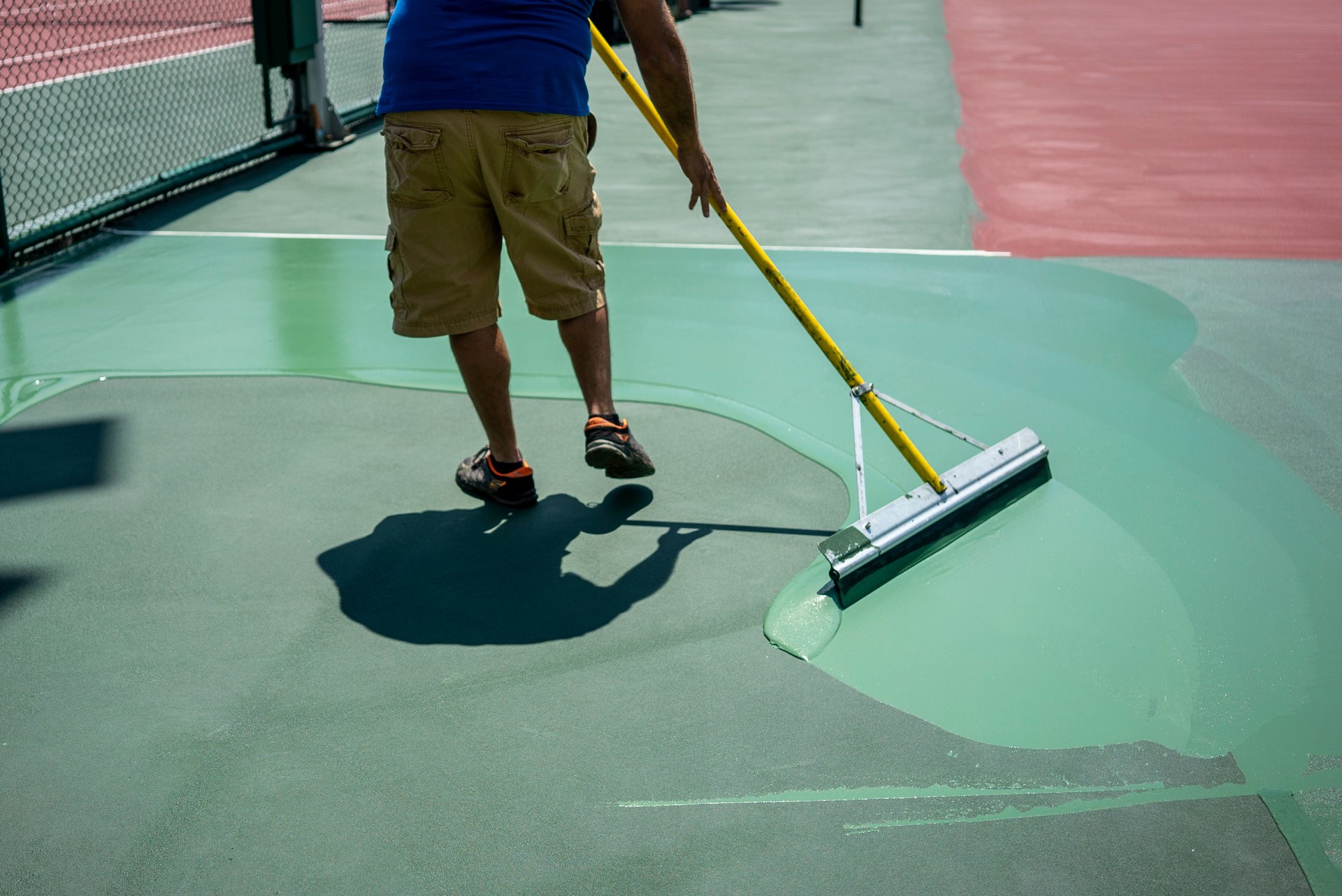 man is painting tennis hard court horizotal photo